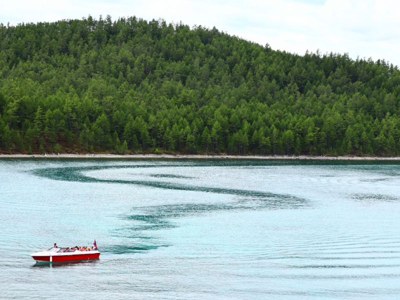 A small boat floating on a large lake